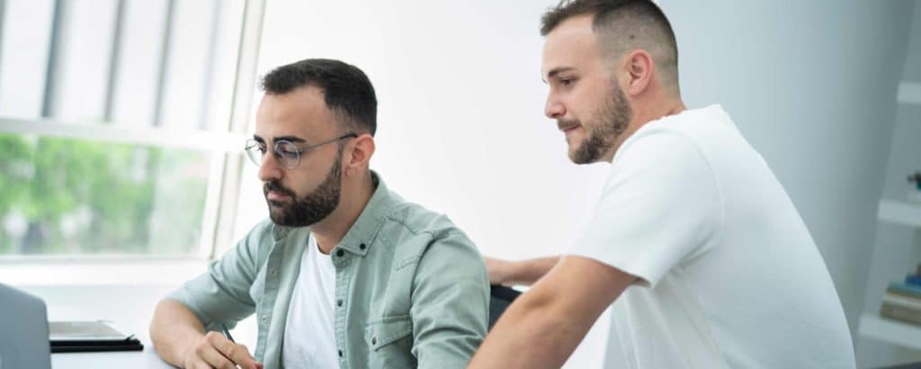 Javier Chiva y Fran trabajando juntos frente a un ordenador